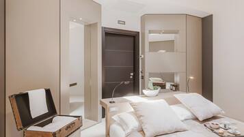 Een moderne hotelkamer met een bed, nachtkastje en een koffer.