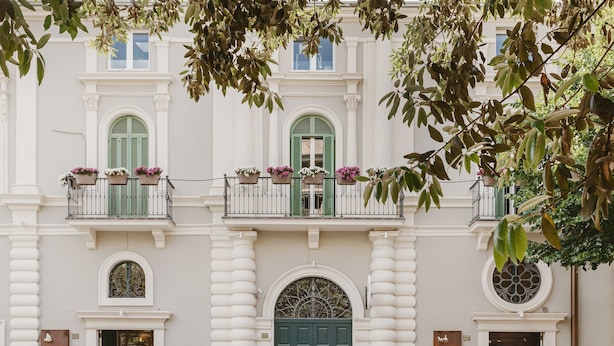 A building with three balconies, each with green shutters and flower boxes. - Residenza del Monaco Bianco (Matera)