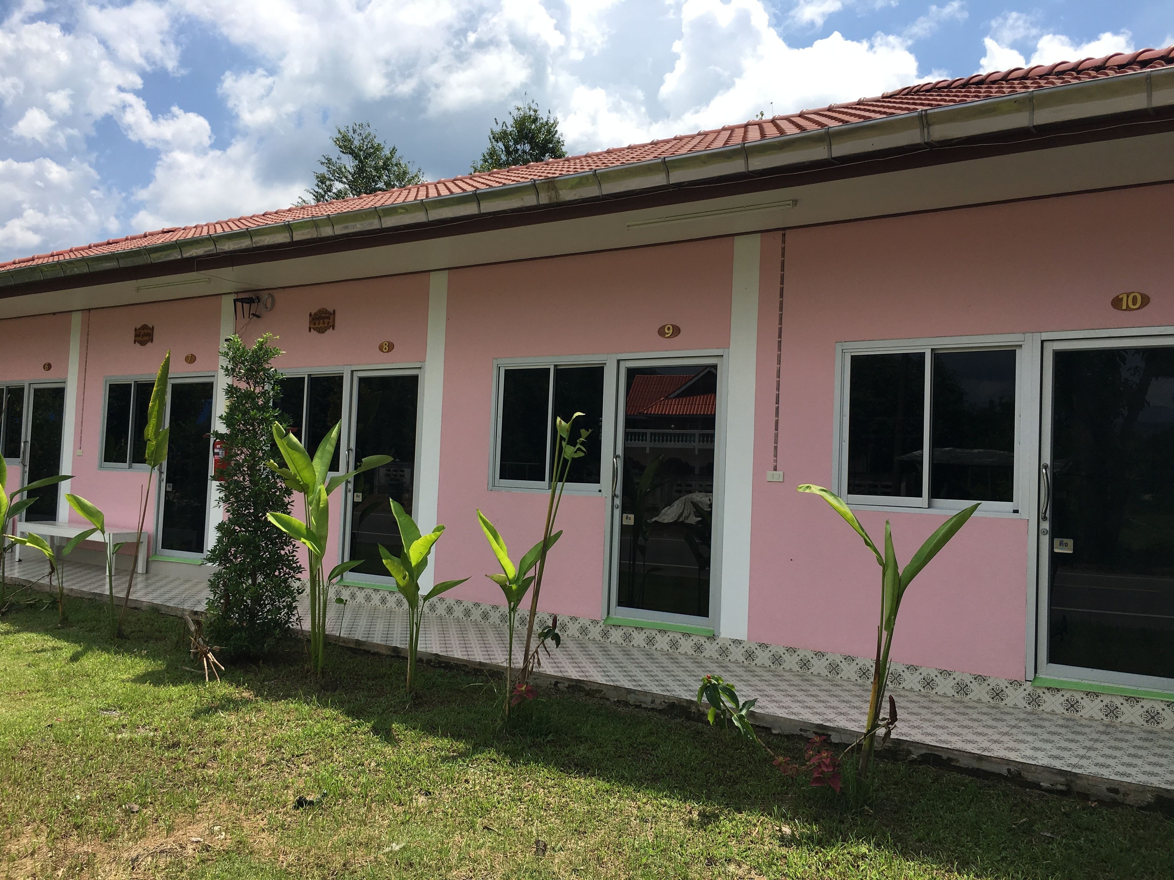 A pink building with numbered windows and a tiled roof.