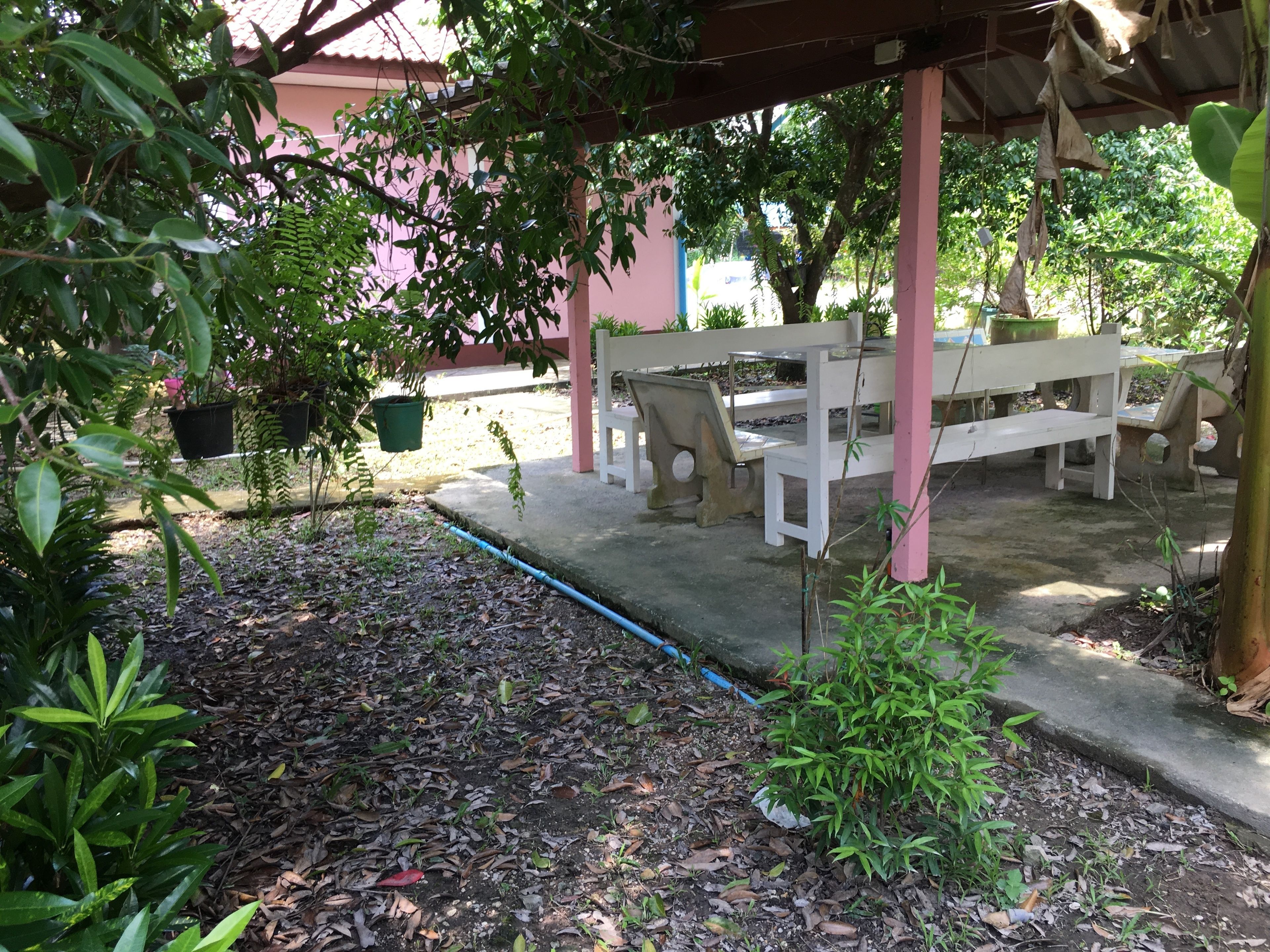 Un espacio de estar al aire libre con bancos y plantas en macetas.