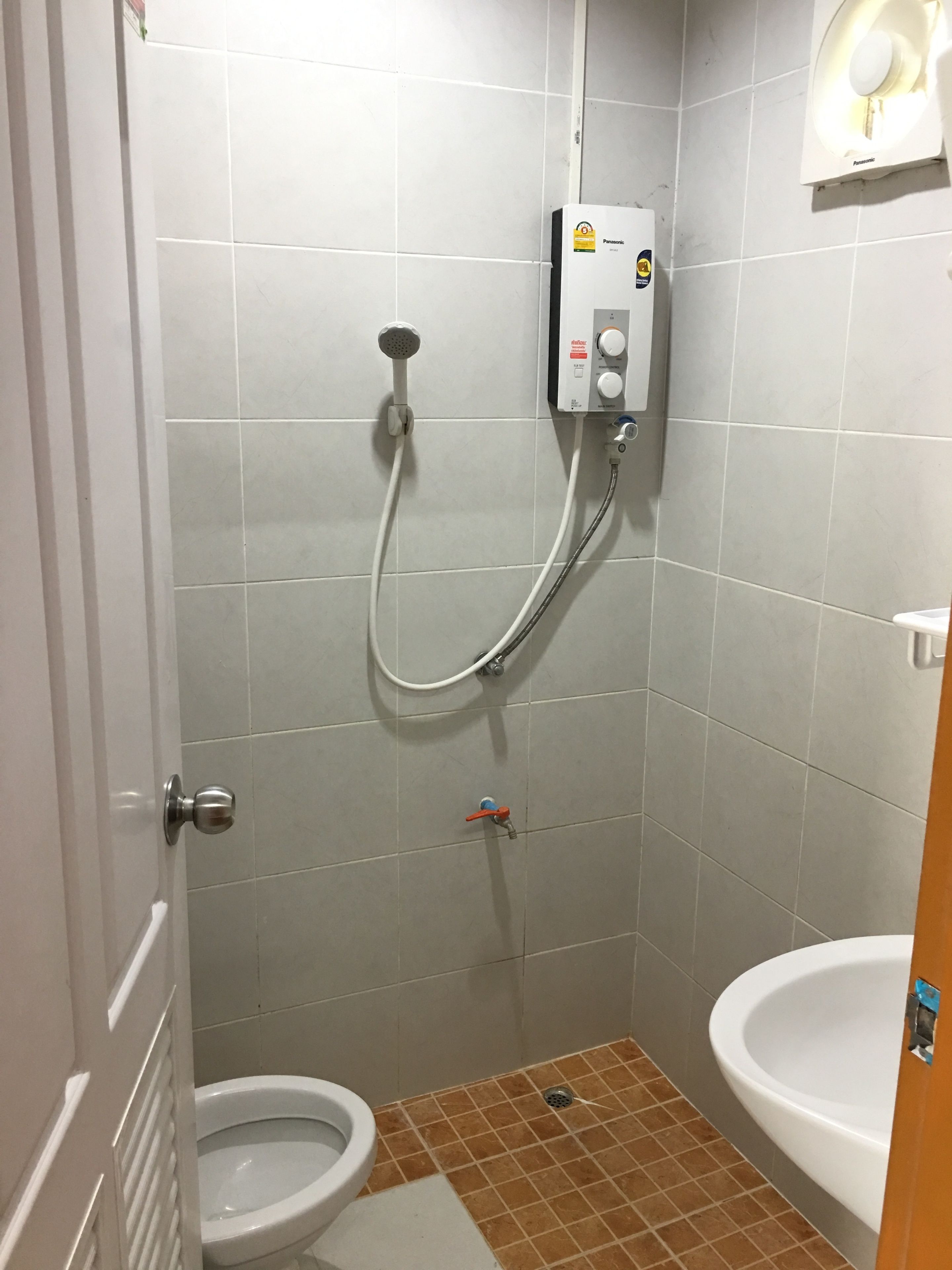 Un baño pequeño con inodoro, lavamanos y cabina de ducha.