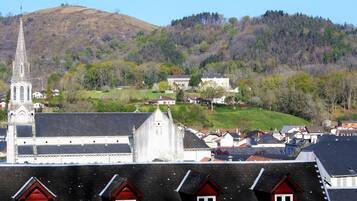 A town with a prominent church steeple, residential buildings, and a hill in the background.
