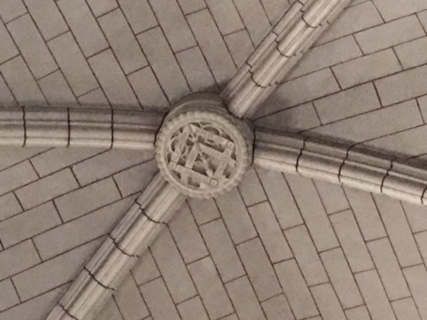 Un techo con un diseño circular central y vigas que irradian desde él.