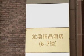 Une enseigne pour l’hôtel « 龙  鼎精品酒店 », situé aux 6e et 7e étages.