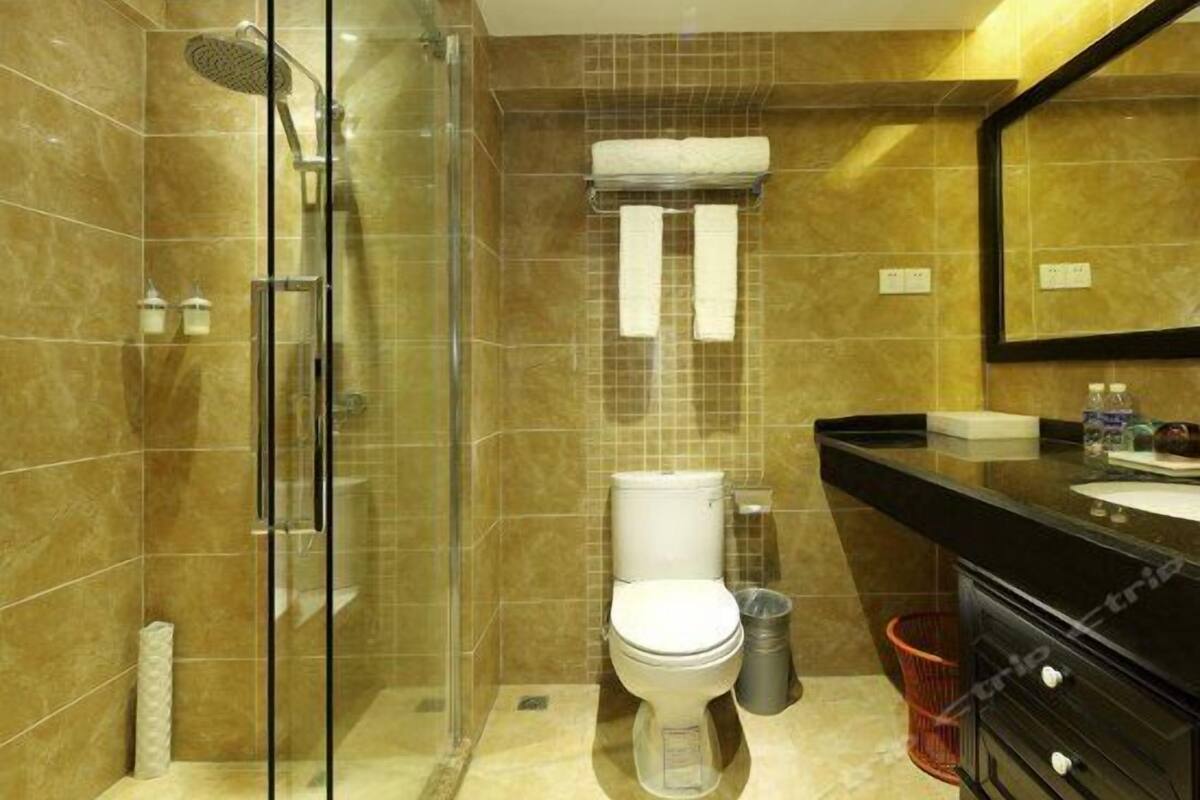 A modern bathroom with a glass-enclosed shower, a toilet, and a vanity with a mirror.