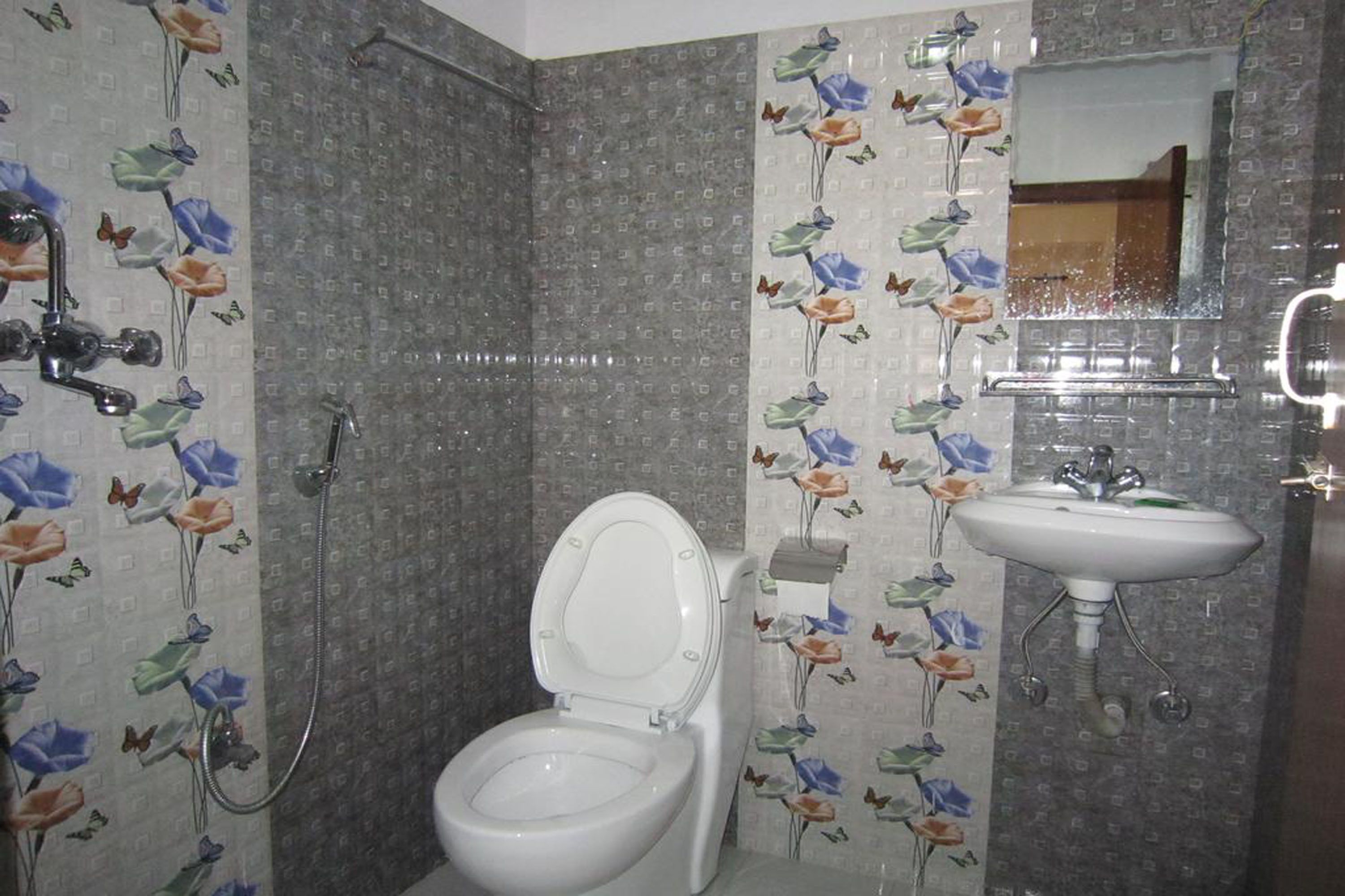 A bathroom with a toilet, shower, and sink.
