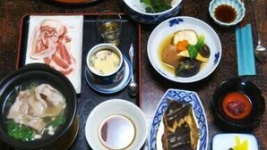 A variety of dishes including soup, meat, and vegetables, arranged on a table with chopsticks and bowls. - Horieya Ryokan (Fukushima)