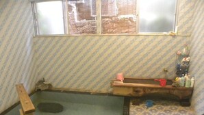 A small room with a window, a wooden bench, and a tiled floor. - Horieya Ryokan (Fukushima)