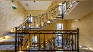 A multi-level marble staircase with ornate black railings and a handrail.