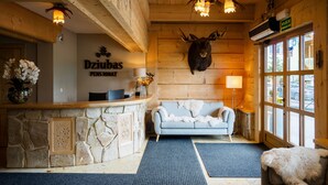 A reception area with a stone counter, a blue sofa, and a mounted deer head.
