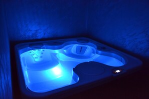 Un bain à remous équipé d’un panneau de commande et d’un seul siège.