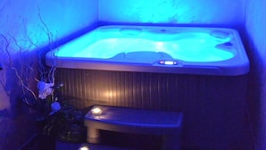 Een bubbelbad in een ruimte met een zwart-wit schakeleparket en een klein opstapje.