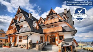 Il s’agit d’un bâtiment traditionnel en bois, doté d’un toit à forte pente, de plusieurs balcons et de fondations en pierre.