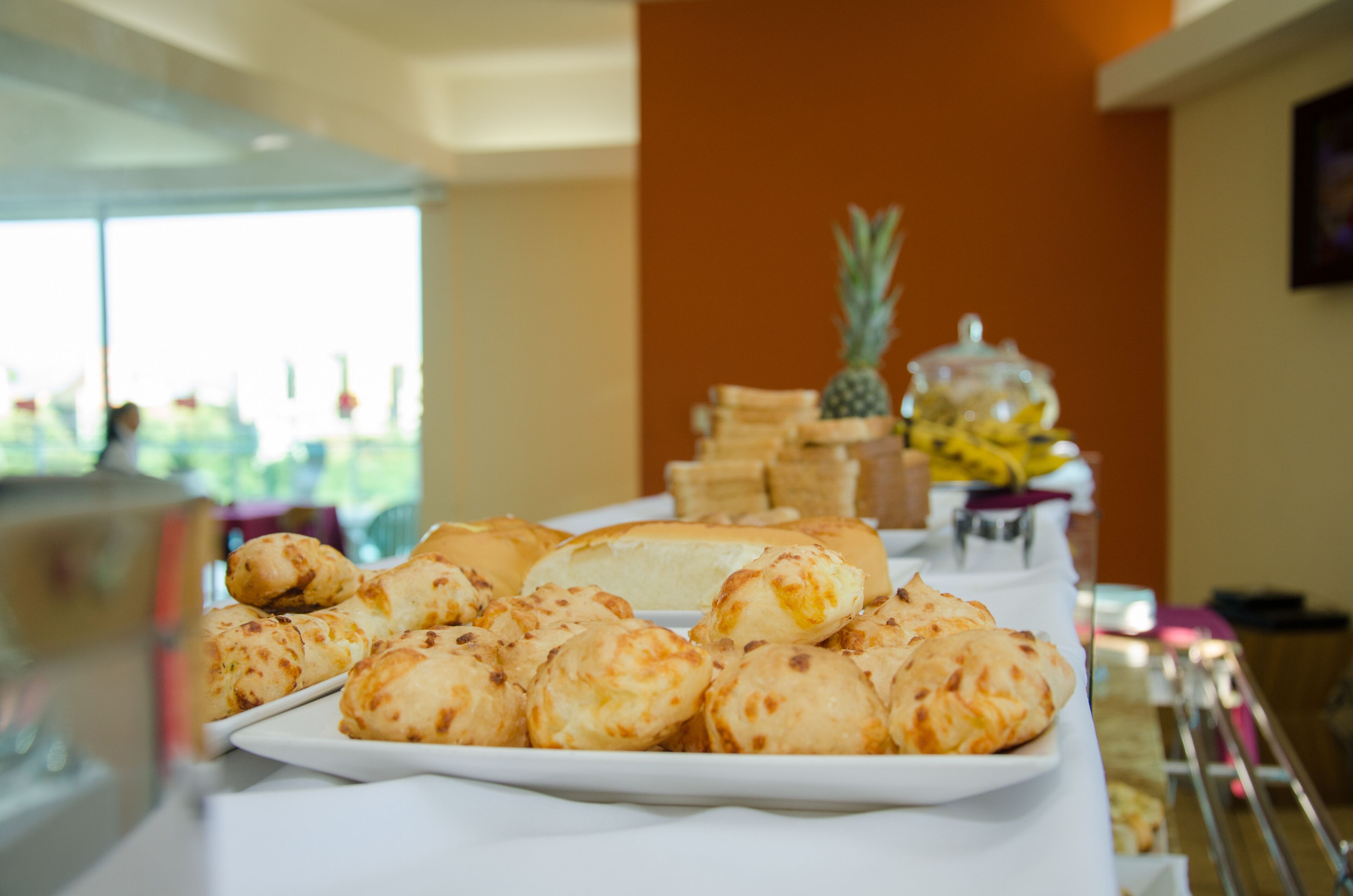 A buffet table with various baked goods and a pineapple.