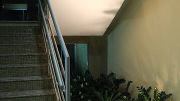 Una escalera con barandillas metálicas que lleva a un rellano.