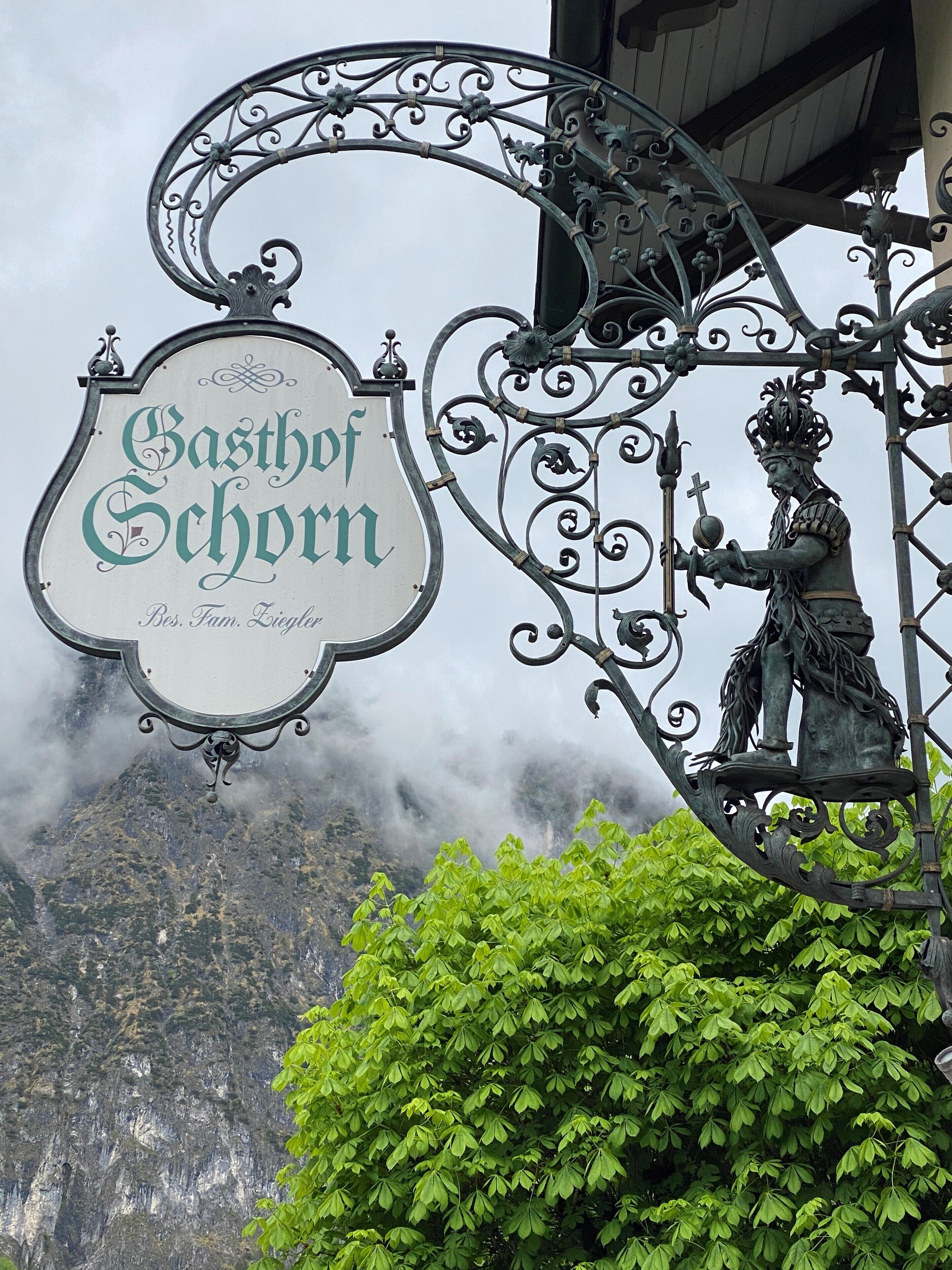 En skylt med texten ”Gasthof Schor” och en staty av en riddare.