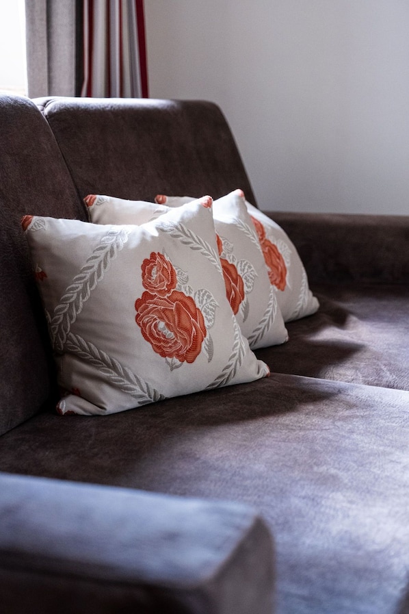 Un sofá con tres almohadas de estampado floral.