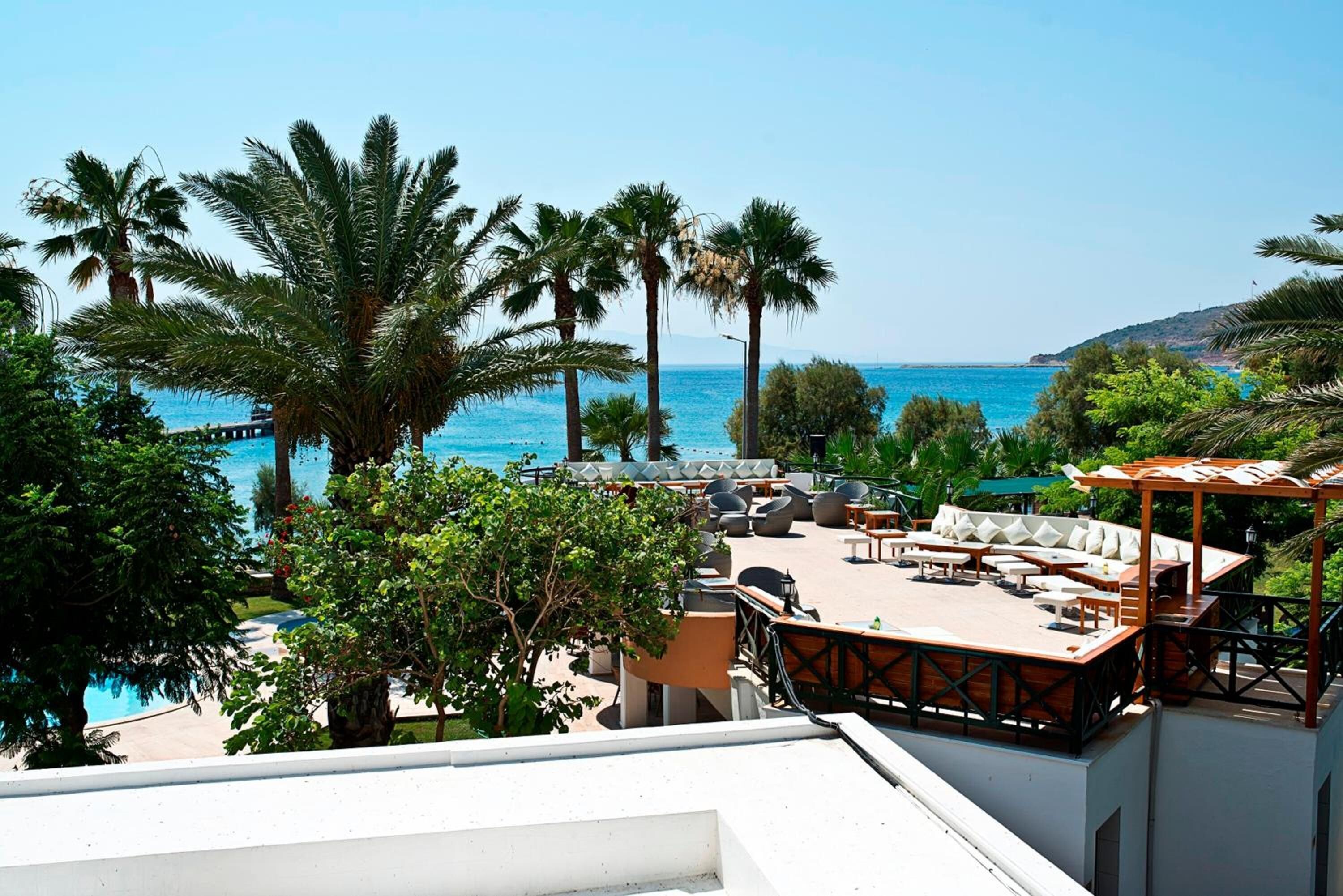 Terraza en la azotea con mobiliario exterior, piscina y vistas al mar.