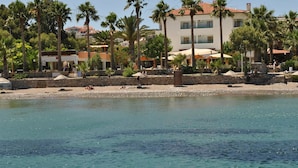 A beachfront hotel with palm trees, a sandy beach, and clear blue water. - Hotel Mare Datca (Datça)