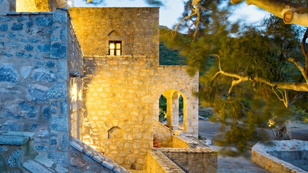 Un edificio de piedra con ventanas arqueadas y una pequeña ventana en la parte superior.