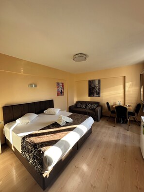 A hotel room with a large bed, a sofa, a small table with chairs, and a painting on the wall. - Beyaz Kosk Hotel (Istanbul)