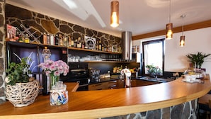 Una cocina con salpicadero de piedra, encimera de madera y luces colgantes.