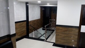 Un interior moderno con una escalera, pisos pulidos y paneles de pared contrastantes.