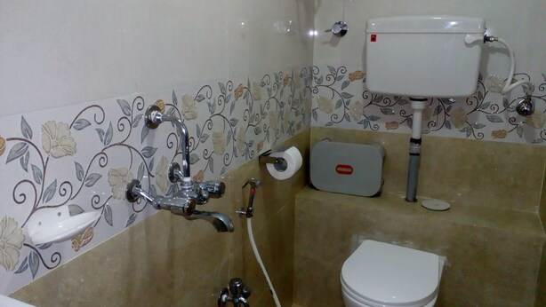 A bathroom with a toilet, a sink, and a shower. - Hotel Sion Residency (Mumbai)