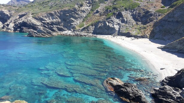 A coastal landscape with clear turquoise waters, rocky cliffs, and a sandy beach. - Argentiera Inn (Sassari)