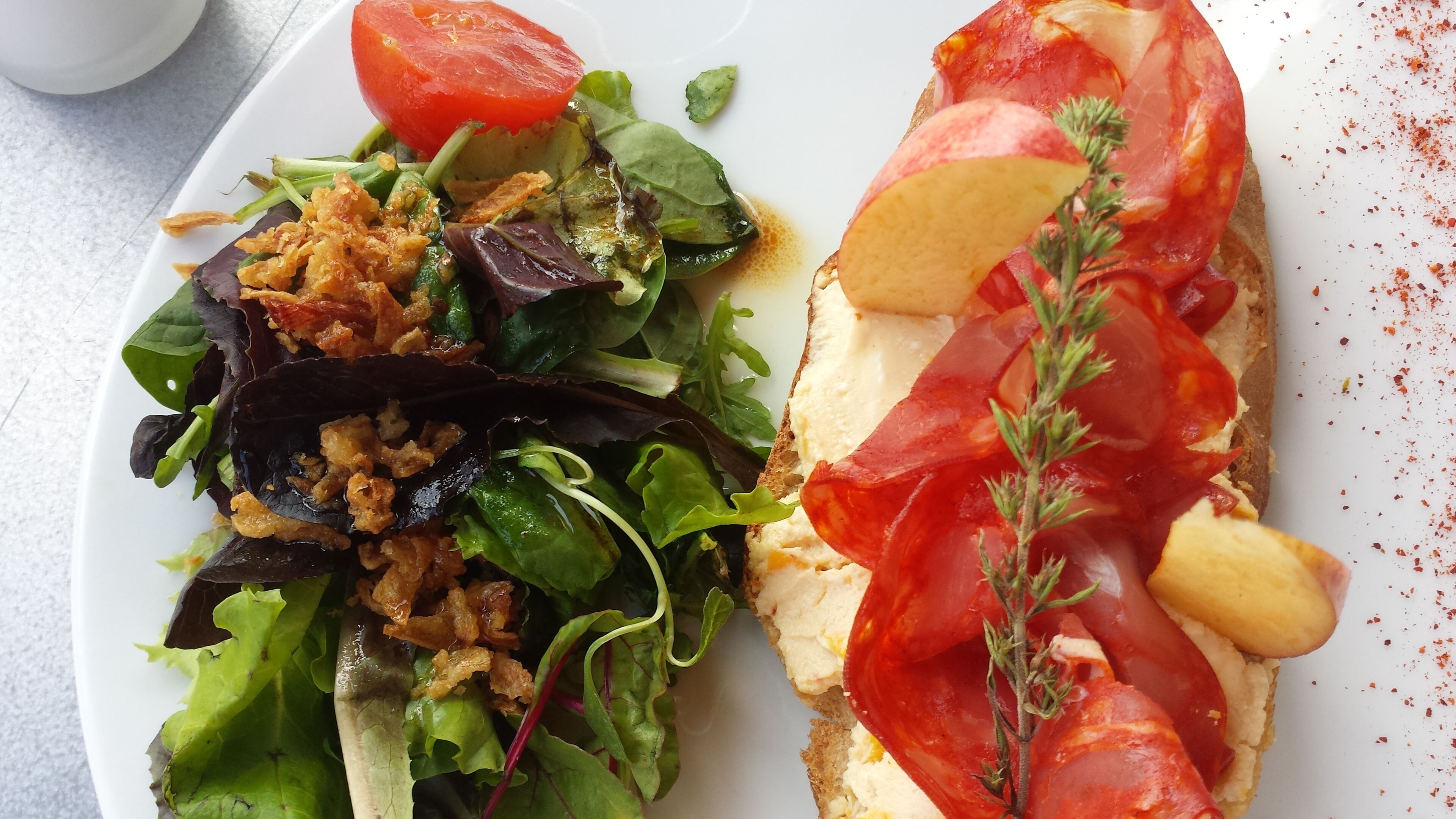 A plate with a sandwich and a salad.