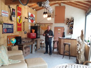 Um interior acolhedor e rústico com paredes de madeira, área de bar e vários avisos.
