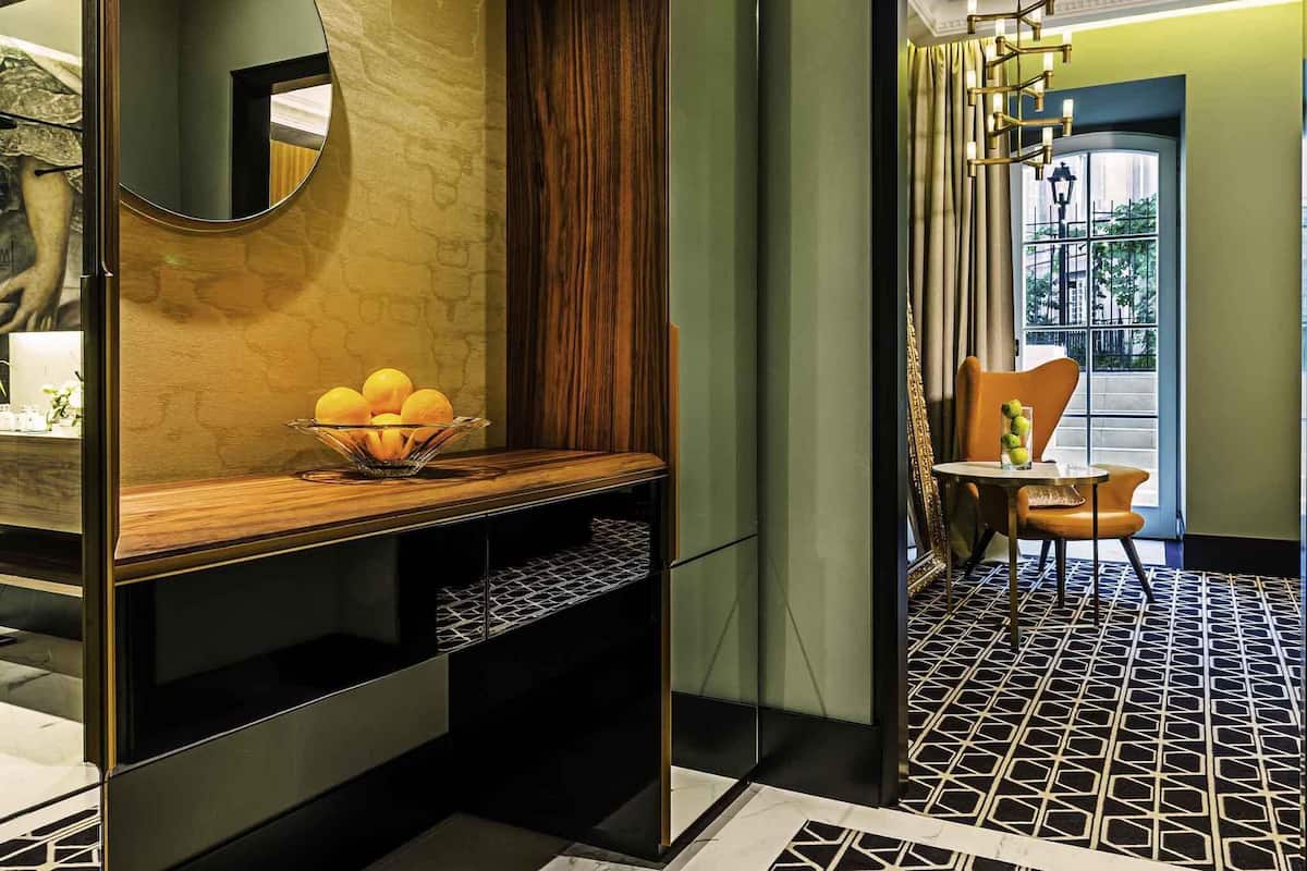 Un baño moderno con un mueble de tocador de madera, un espejo y un cuenco de limones.