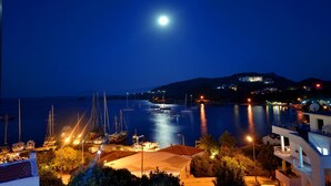A marina at night with boats docked, a clear sky, and a building in the background. - Doada Hotel (Datça)