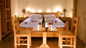 A neatly made bed with white linens, a bottle of wine, and two glasses on a wooden table in a hotel room. - Doada Hotel (Datça)