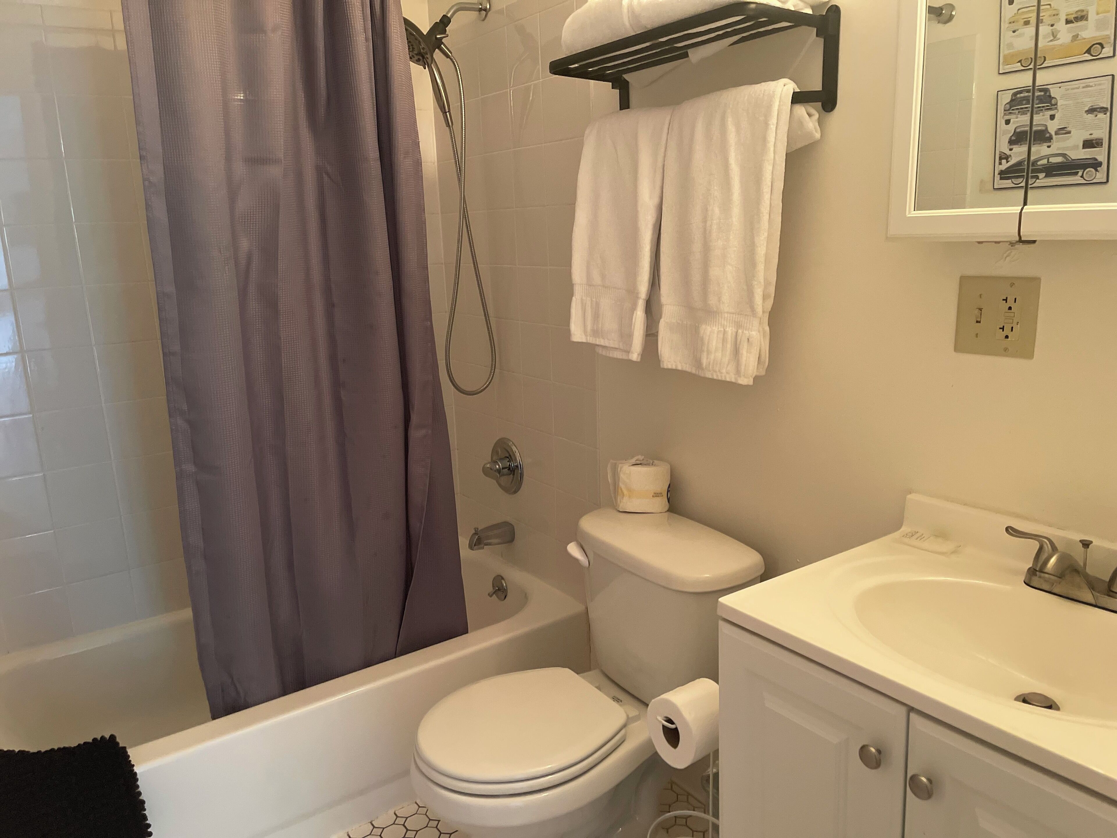 A bathroom with a bathtub, toilet, and sink.