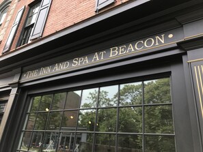 Exterior do The Inn and Spa at Beacon, com fachada preta, letras douradas e grandes janelas refletindo árvores e luzes.