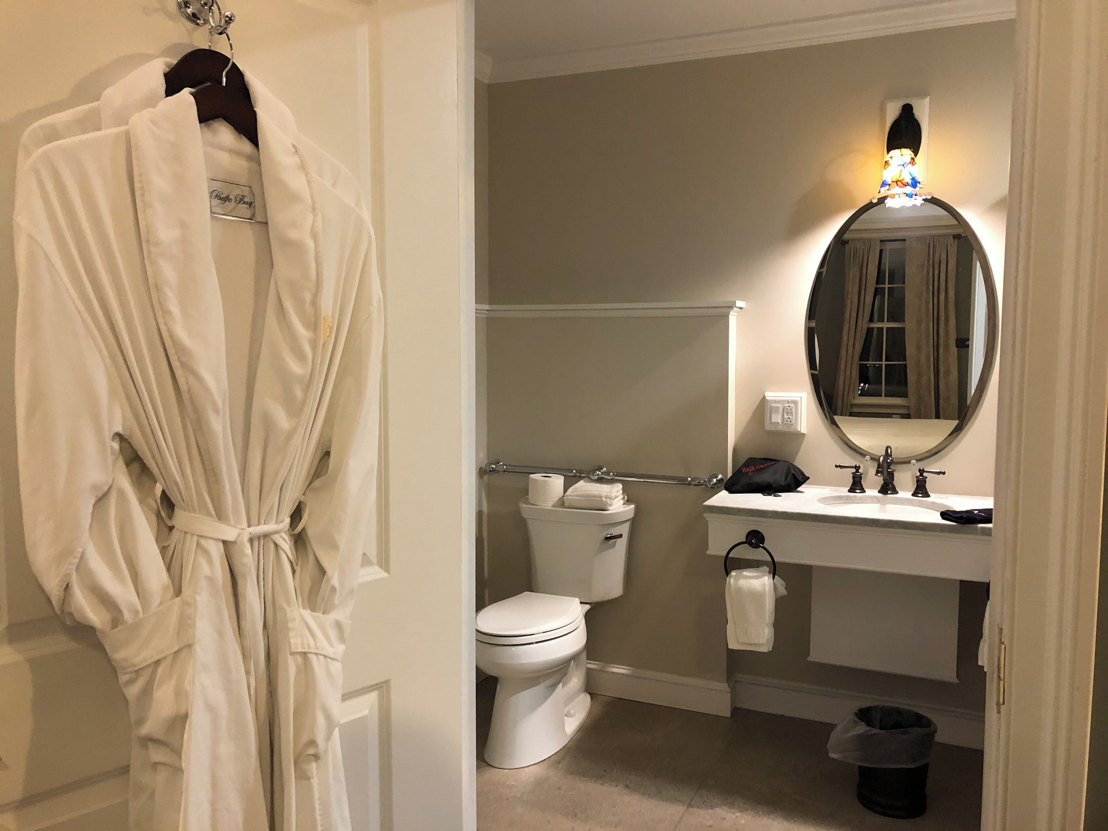 Un baño con inodoro, lavamanos y espejo.
