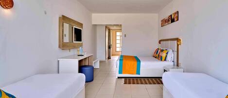 A hotel room with two single beds, a desk, a chair, a mirror, and a large window.