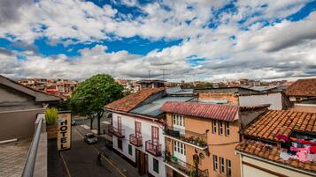 Un hotel con techo rojo, paredes blancas y balcones con barandillas.