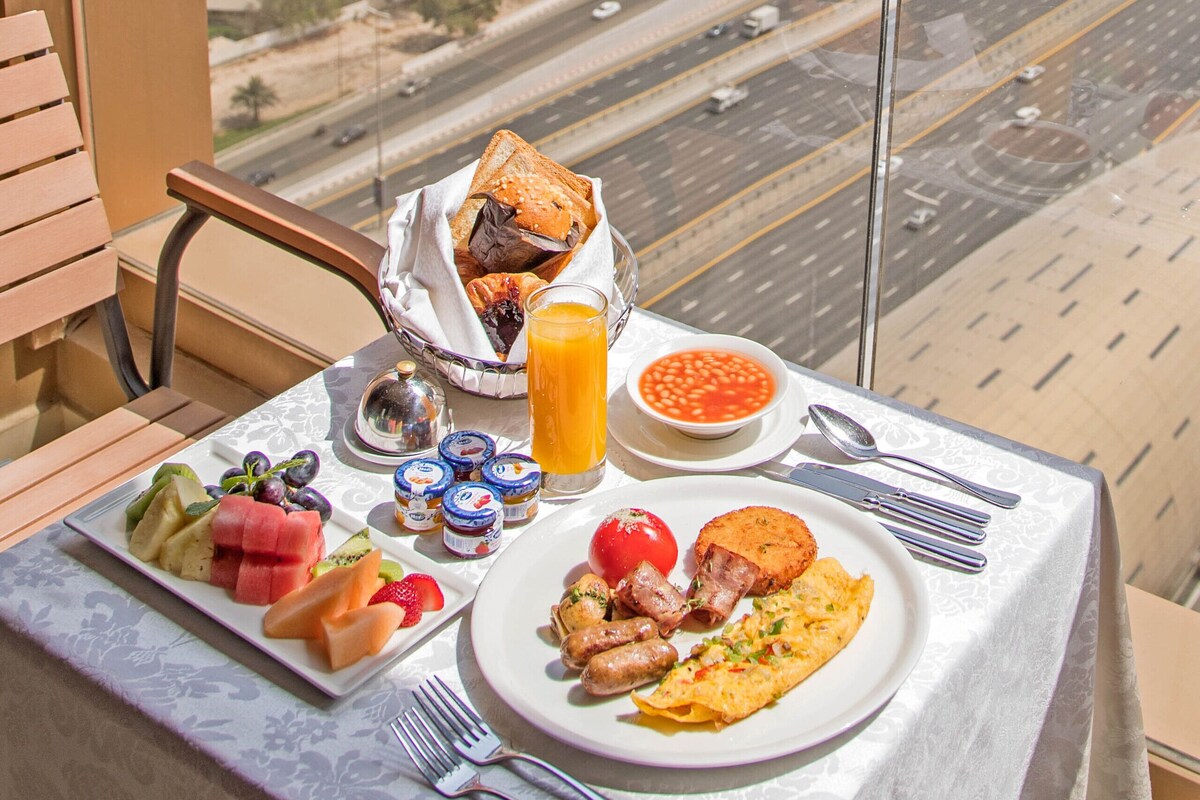 Une table sur un balcon, avec un petit-déjeuner et une vue sur la ville.