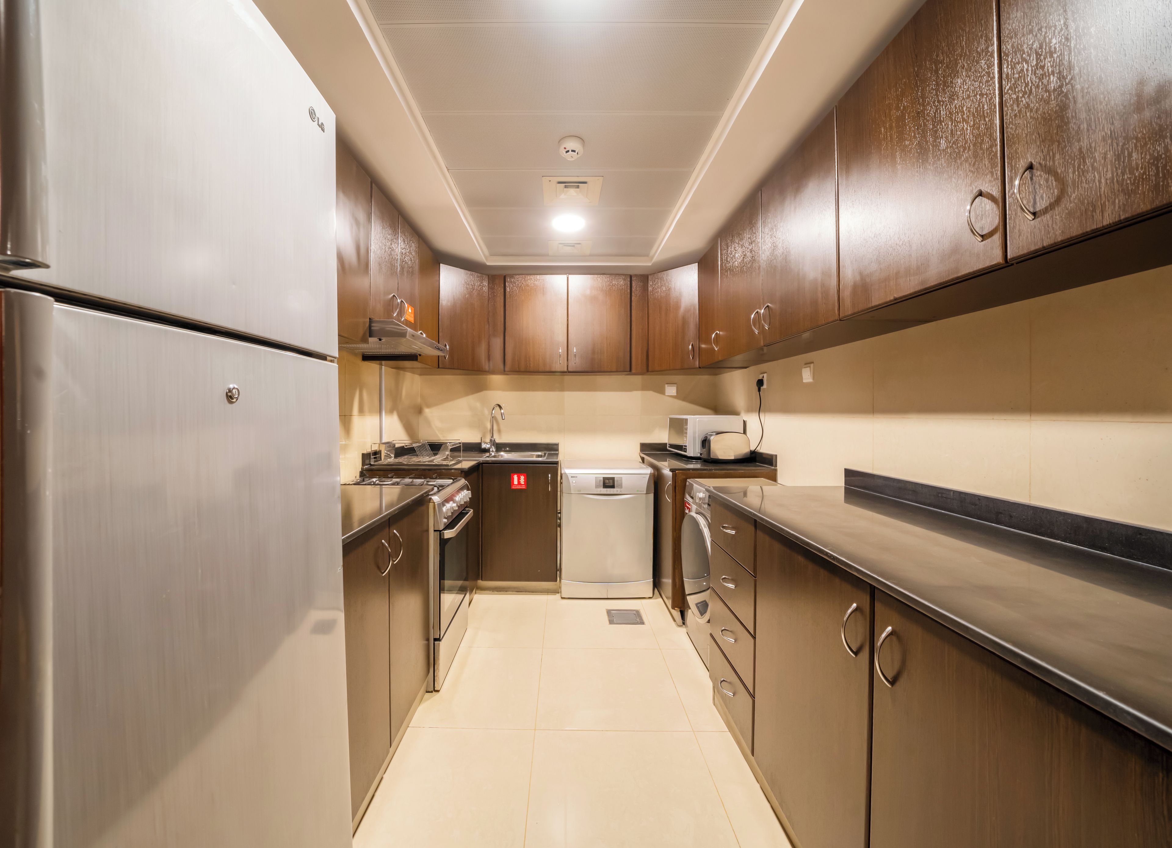Una cocina moderna con electrodomésticos de acero inoxidable, armarios de madera y salpicadero de azulejos.