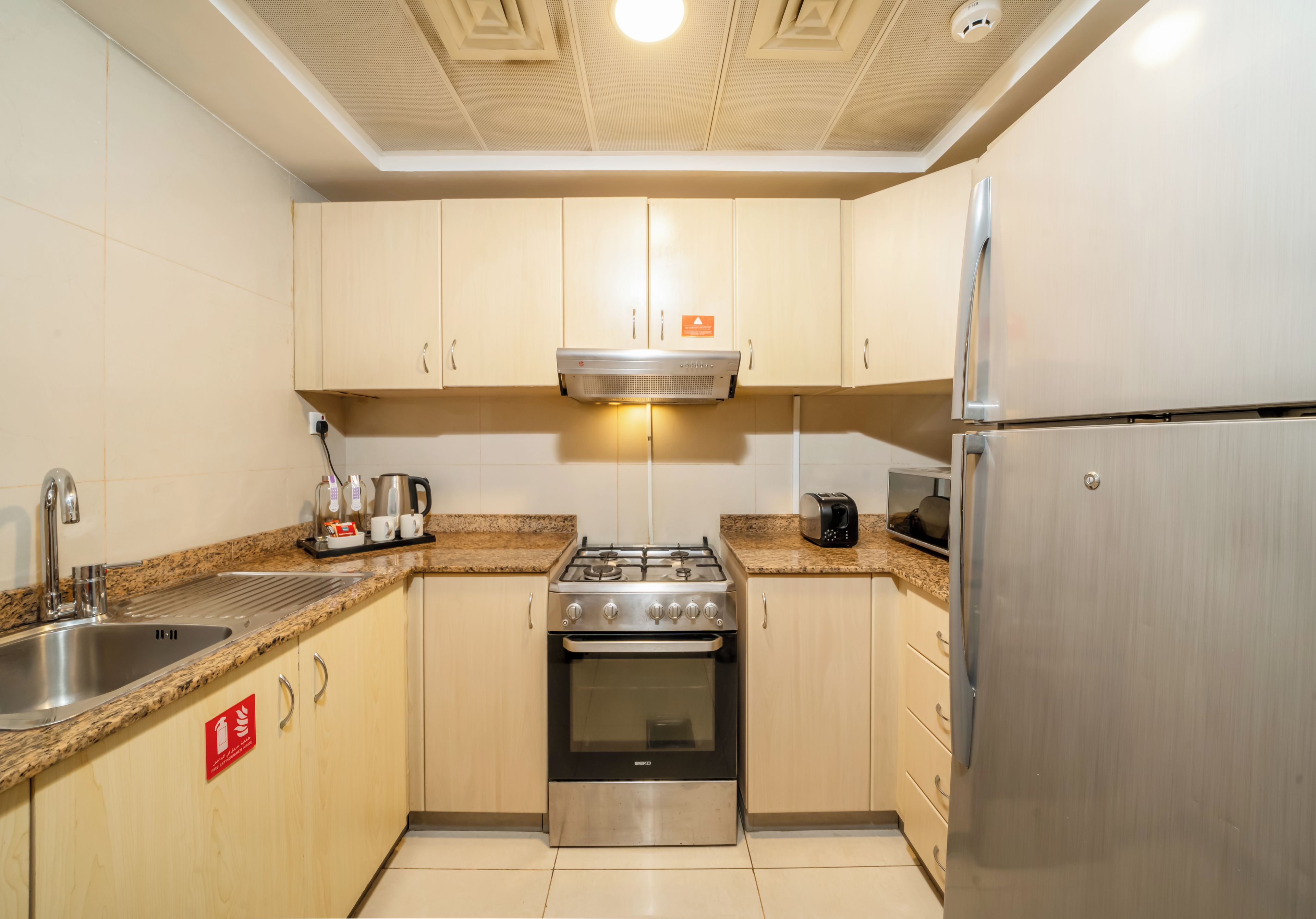 A modern kitchen with a gas stove, stainless steel appliances, and a built-in oven.