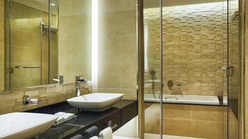 A modern bathroom with two sinks, a glass-enclosed shower, and a large mirror.