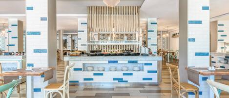 Um restaurante moderno com balcão central, diversas opções de assento e design contemporâneo.