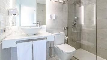 A modern bathroom with a white sink, toilet, and shower.