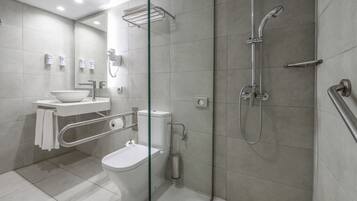 A modern bathroom with a glass partition, a toilet, a sink, and a shower area.