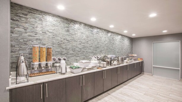Una cocina moderna con una barra amplia, varios dispensadores de alimentos y un revoque de azulejos.