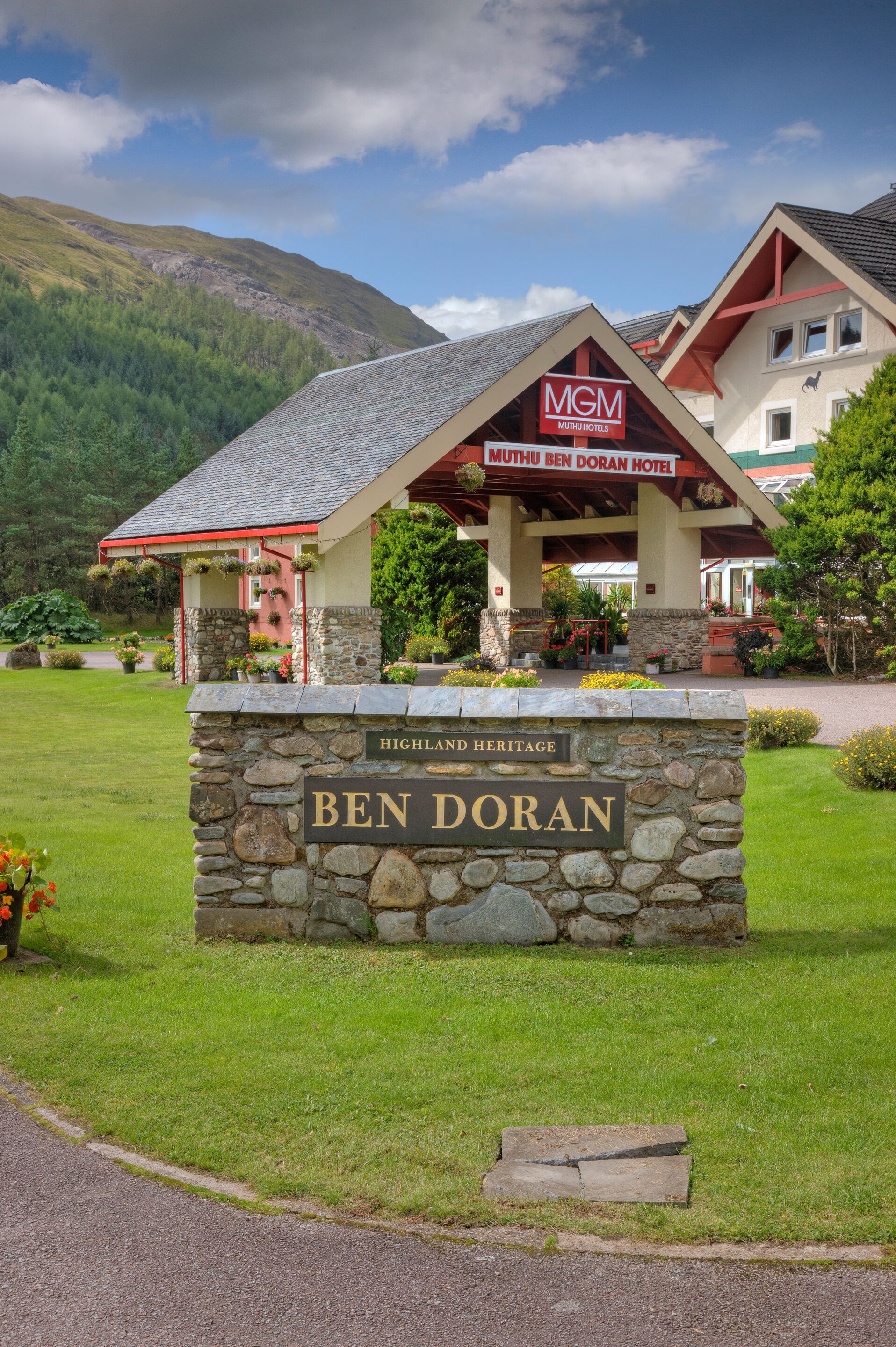A hotel with a stone sign reading "Ben Doran" and a building with a red roof and "MGM Mutiny Hotels" sign.