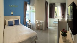 A bedroom with a bed, a desk, and a TV. - The Garden Living (Bangkok)