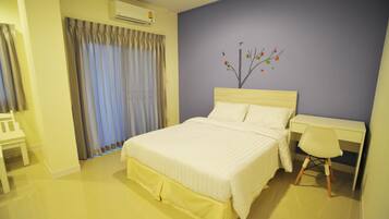 Un dormitorio ordenado con cama, escritorio y silla.